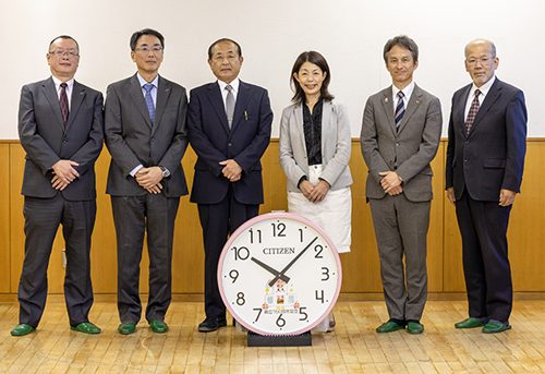 創立150周年ソーラー電波時計と小金井市立小金井第一小学校の教員の皆様の集合写真